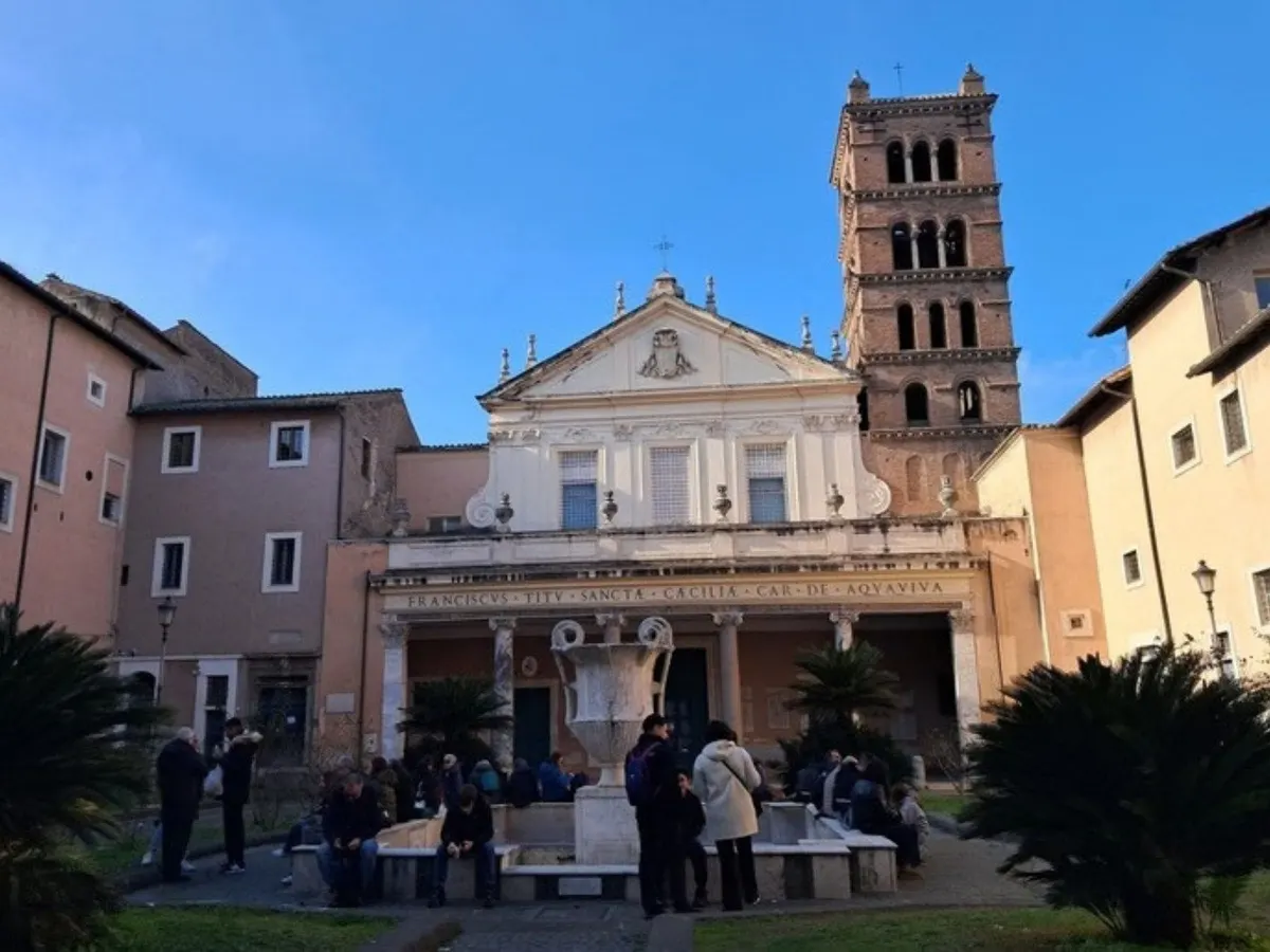 Cresimandi e famiglie nel cortile di una basilica romana durante il pellegrinaggio delle sette chiese